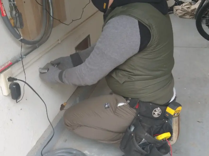 Electrician performing outlet wiring in a Rochelle Park garage